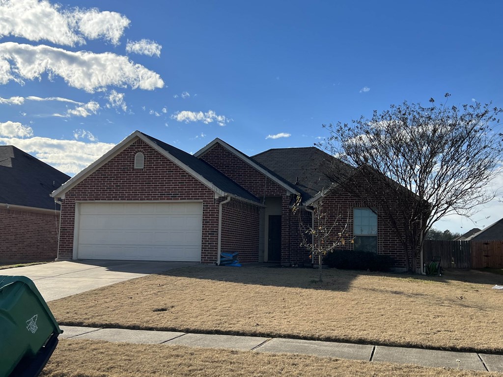 a brick house with a white garage door and a blue sky