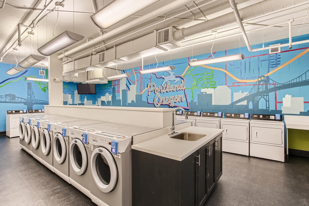 a large laundry room with washers and dryers and a mural on the wall