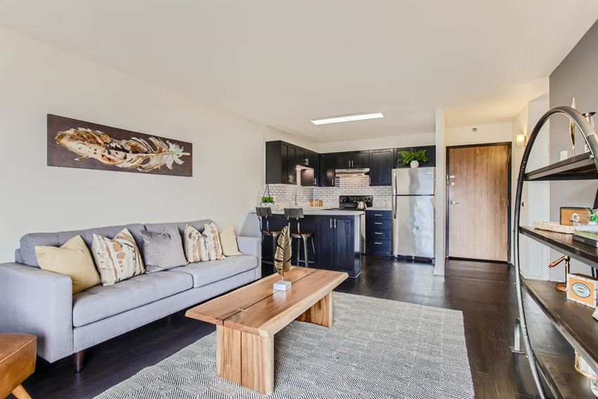 a living room with a couch and a coffee table in front of a kitchen