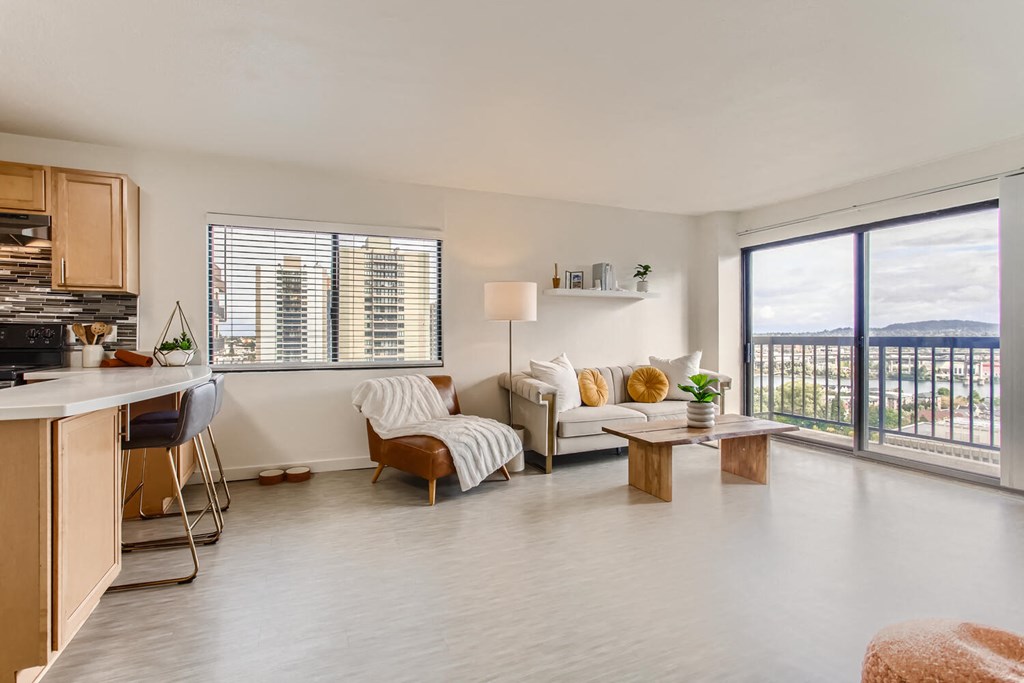 a living room with a couch and a table     and a kitchen
