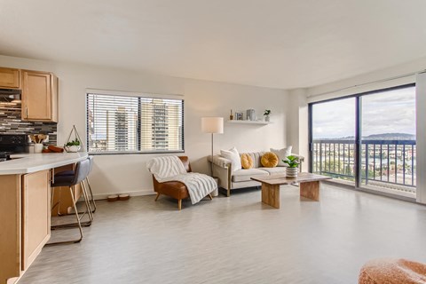 a living room with a couch and a table     and a kitchen