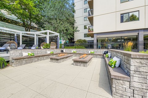 A patio area with a white pergola and stone benches.