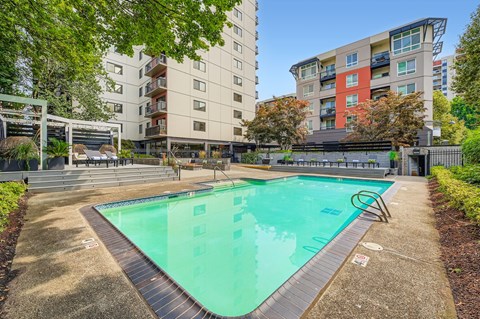 A swimming pool surrounded by apartment buildings.