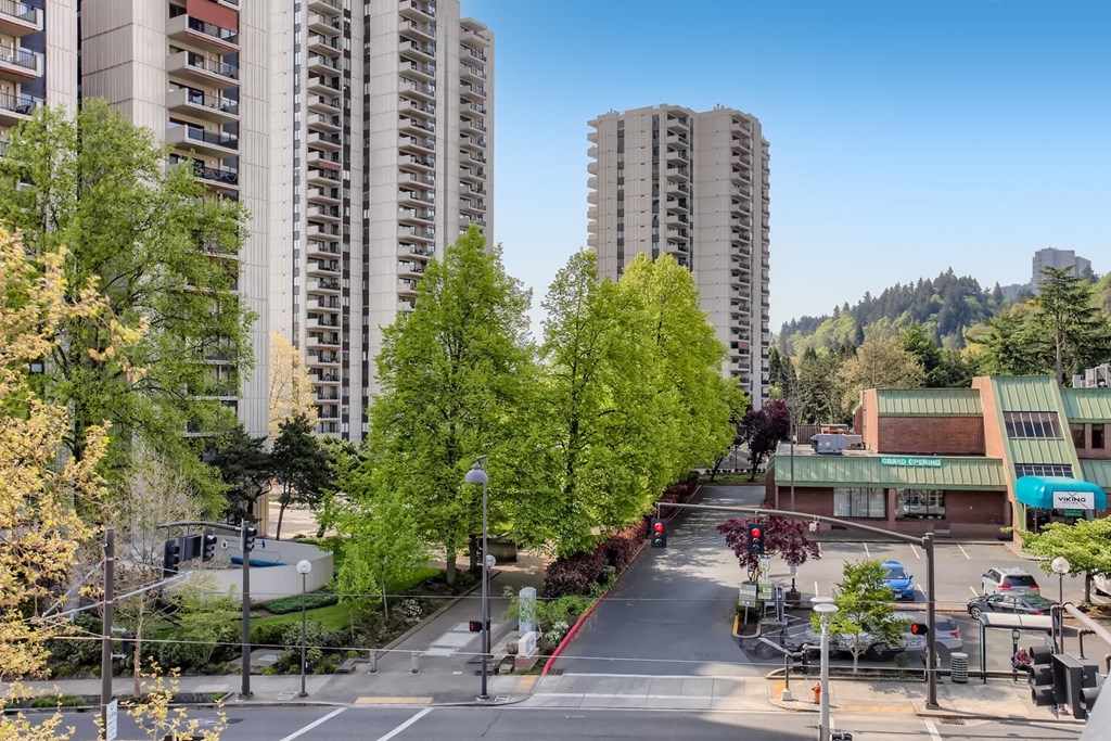 an aerial view of a city street with tall buildings and trees