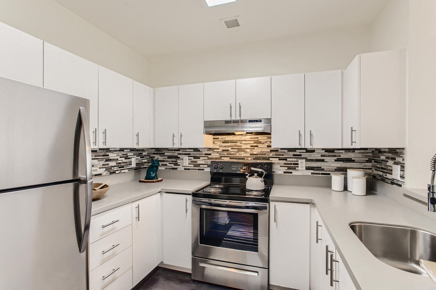 Apartments for Rent in Downtown Portland OR - Linc 245 - White Kitchen with Stainless Steel Appliances and a Tiled Backsplash