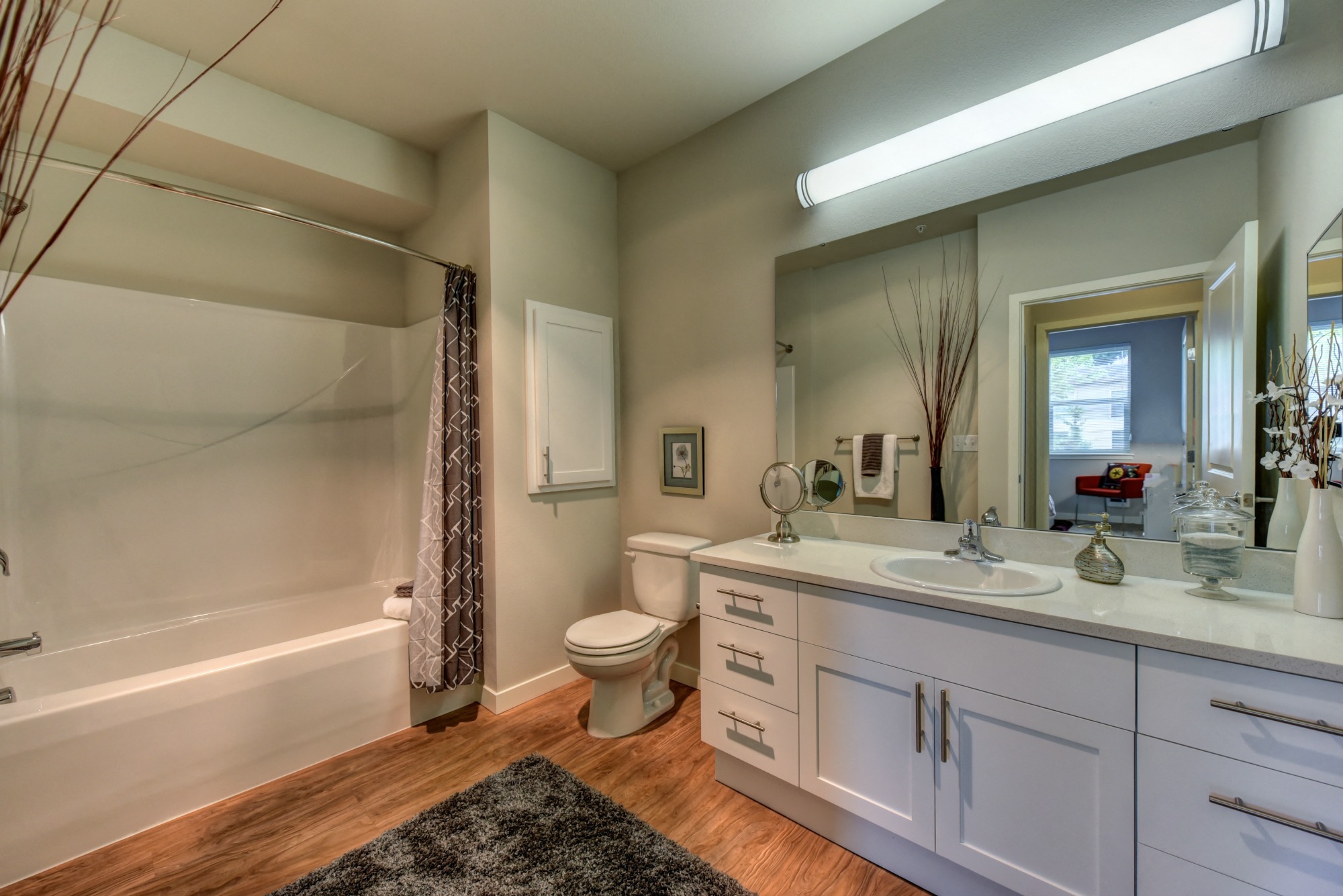 Bathroom with Wood Inspired Floor, Rug, Vanity and Bathtub