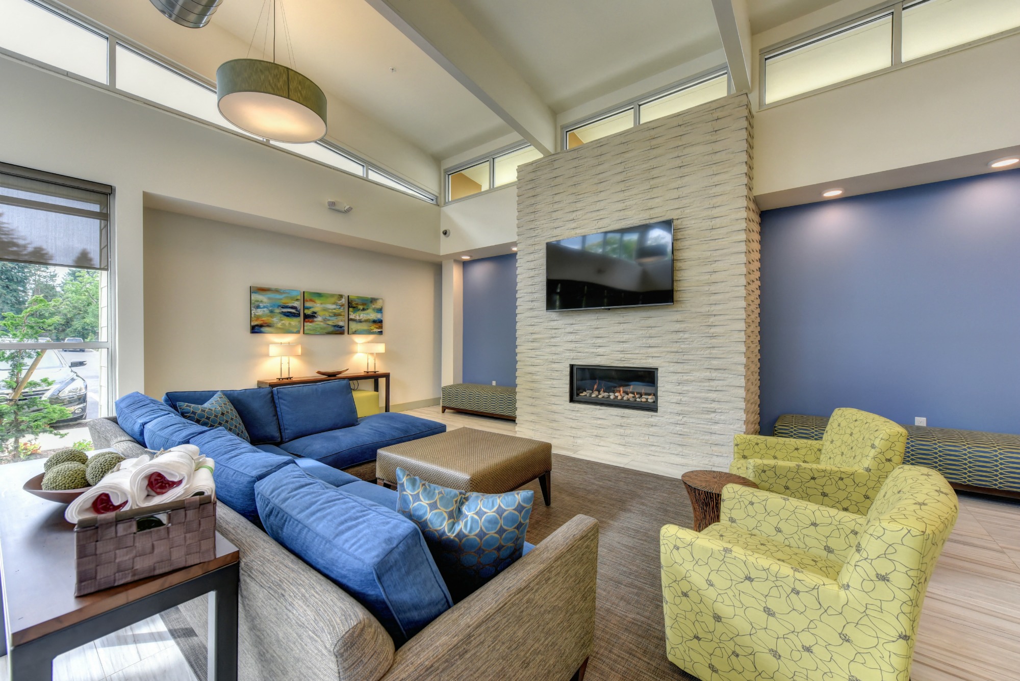 Community Clubhouse Lounge with Fireplace, Lime Sofa Chairs, Mounted Flat Screen Television and Table Lamps