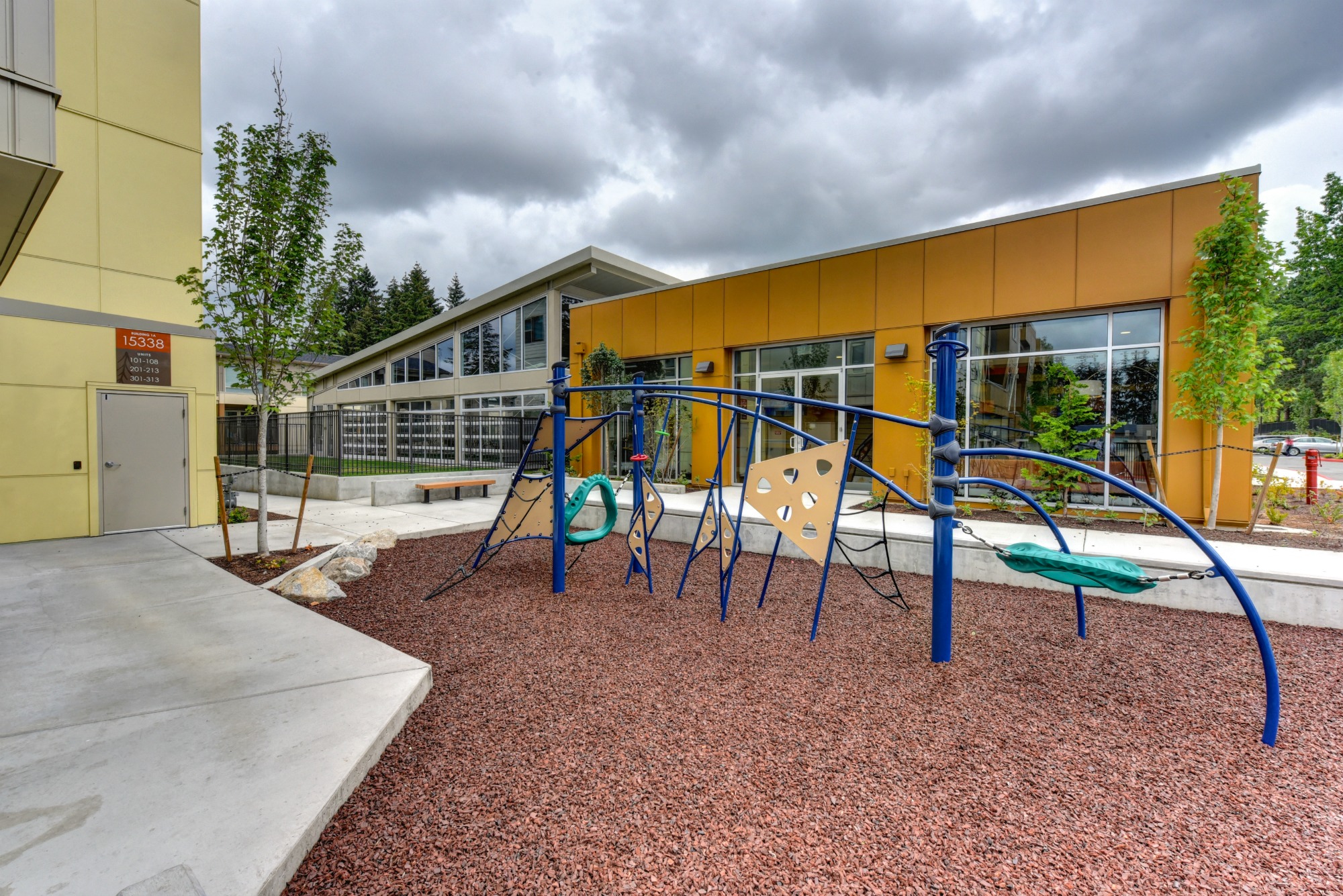 Outdoor Playground with Jungle Gym, Wood Chip Floor, Rocks and Building Exterior