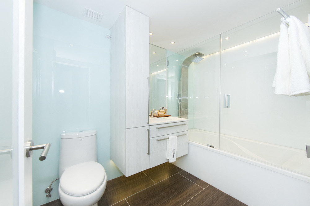 a bathroom with a white toilet and a glass shower