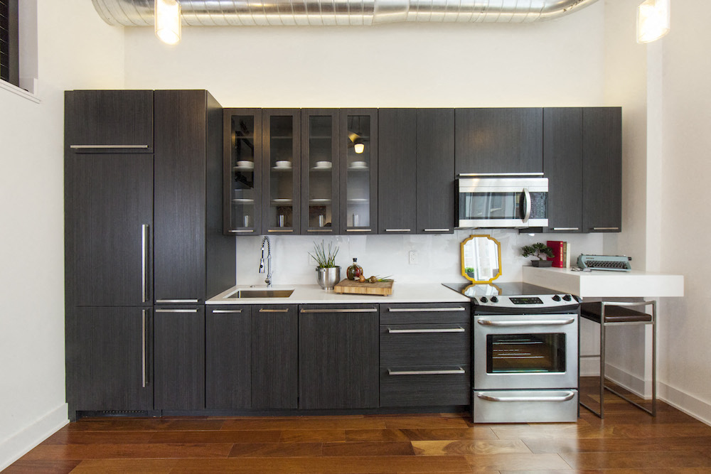 a kitchen with black cabinets and stainless steel appliances