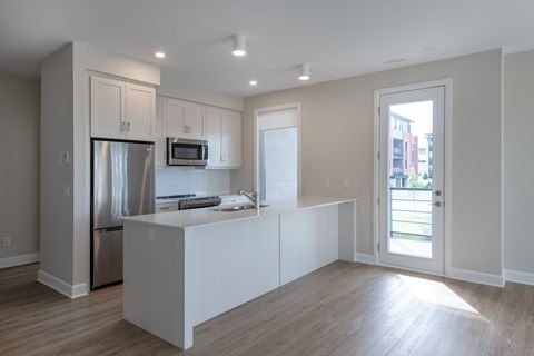 a kitchen with white cabinets and a stainless steel refrigerator