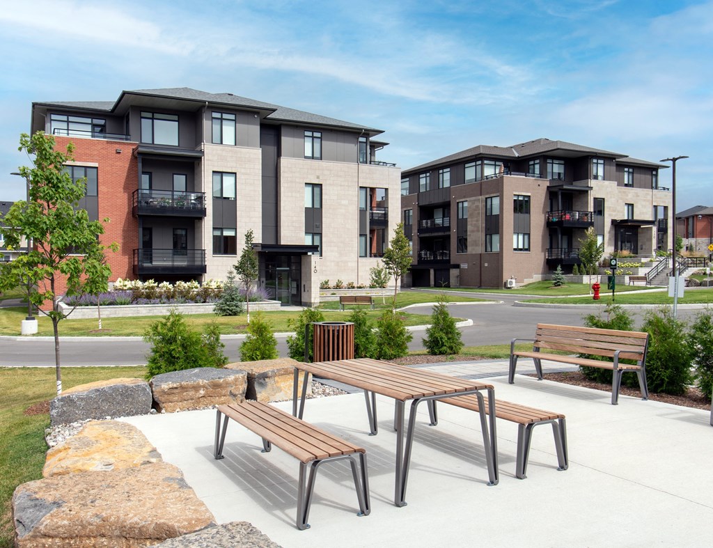 two benches and a table in front of some apartment buildings
