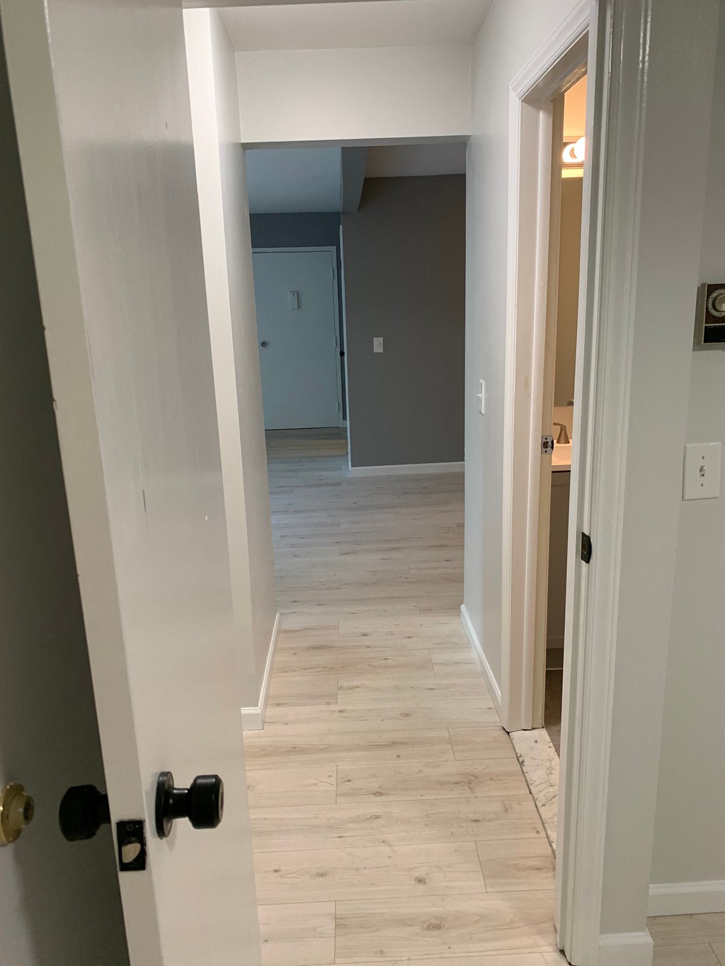 a look down the hallway from the closet into the living room
