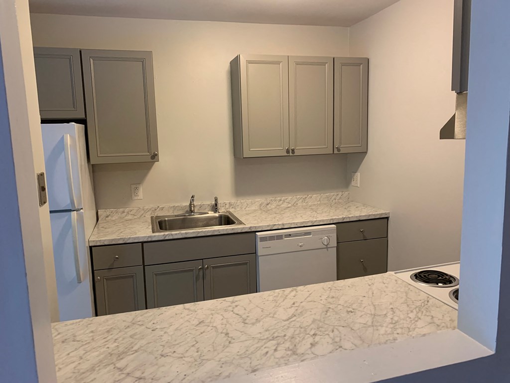 a kitchen with granite counter tops and white cabinets