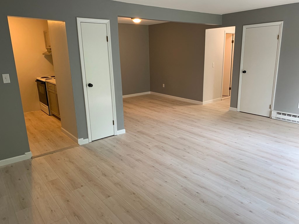 a renovated living room with wood floors and doors
