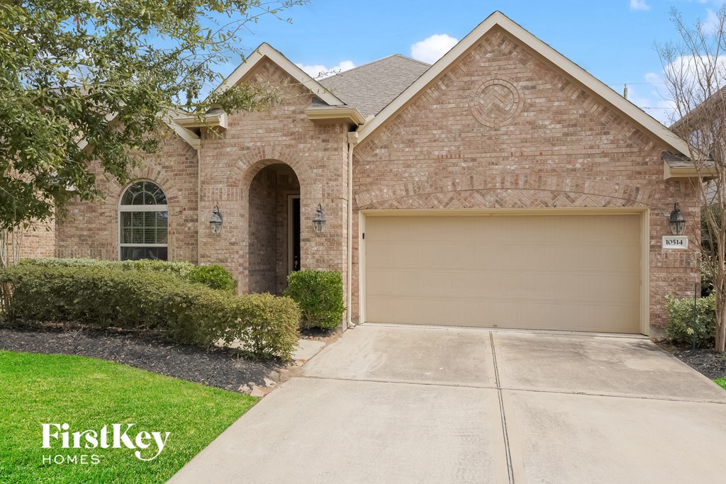 a brick house with a garage door and a driveway