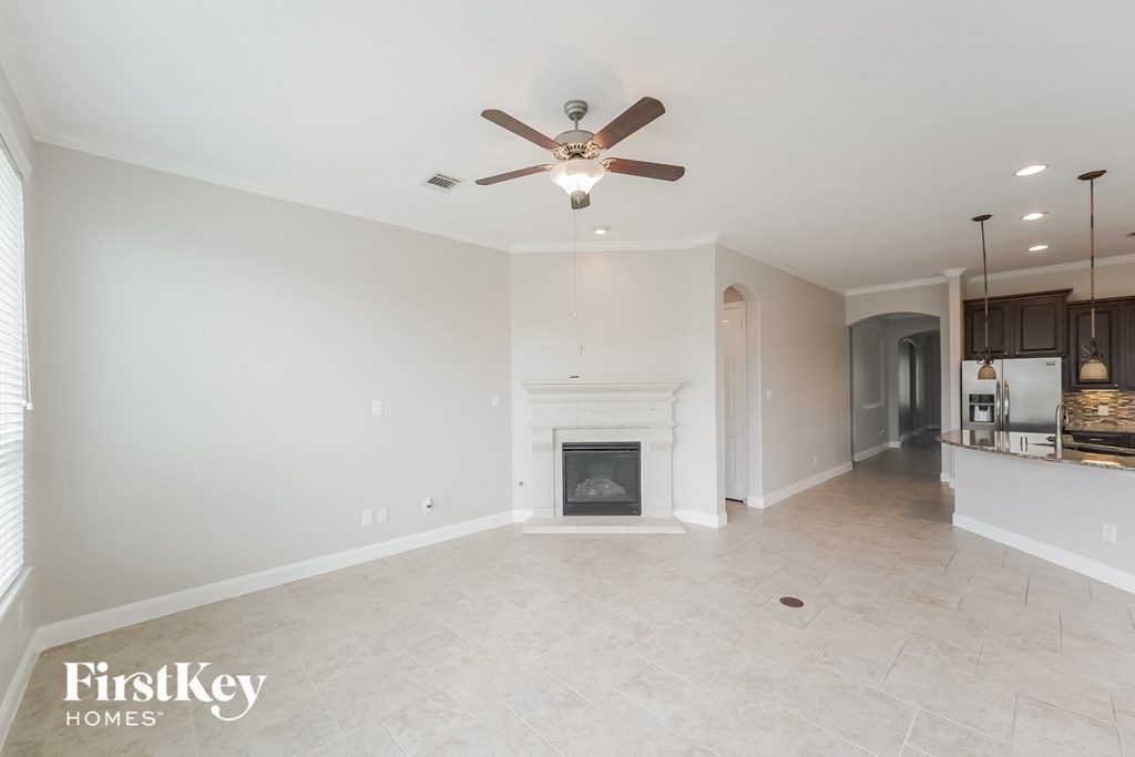a living room with a fireplace and a ceiling fan