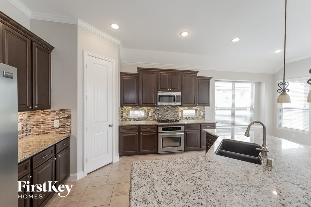 a kitchen with granite counter tops and wooden cabinets