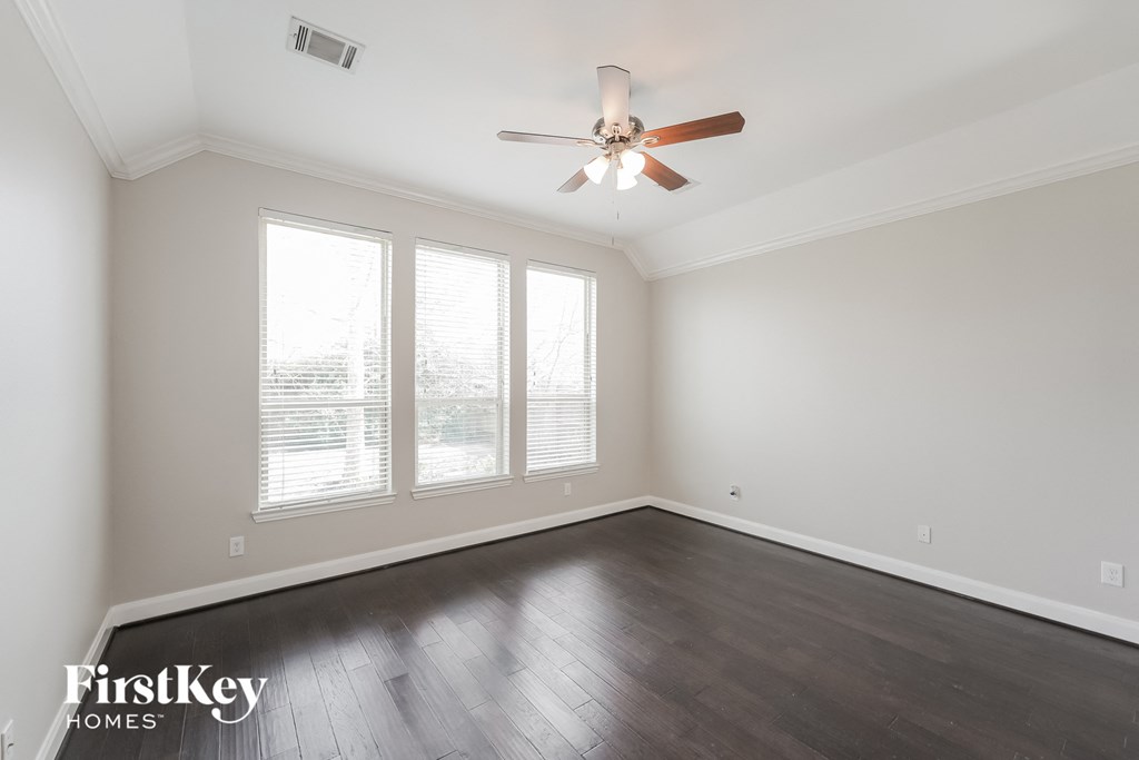 a living room with wood floors and a ceiling fan