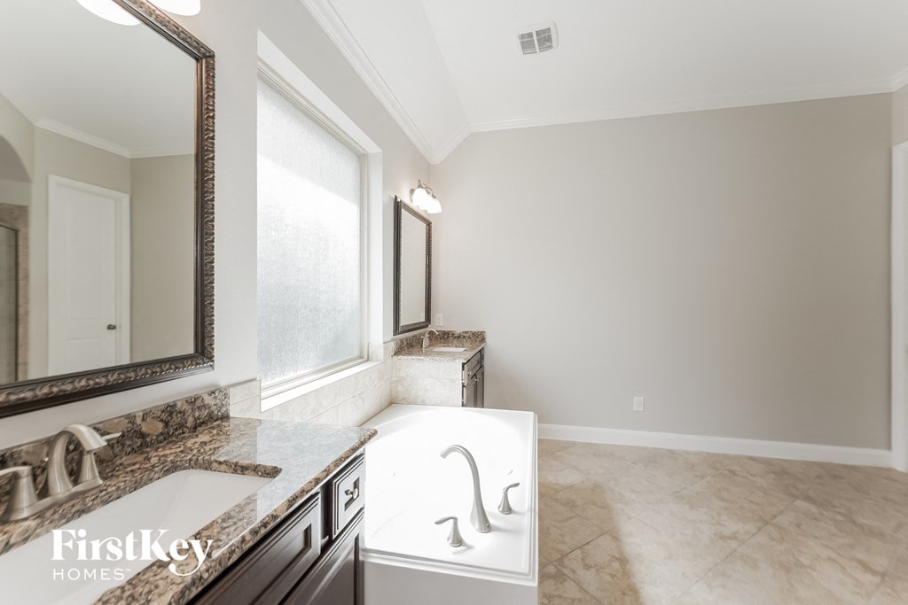 a bathroom with a tub and a sink and a mirror