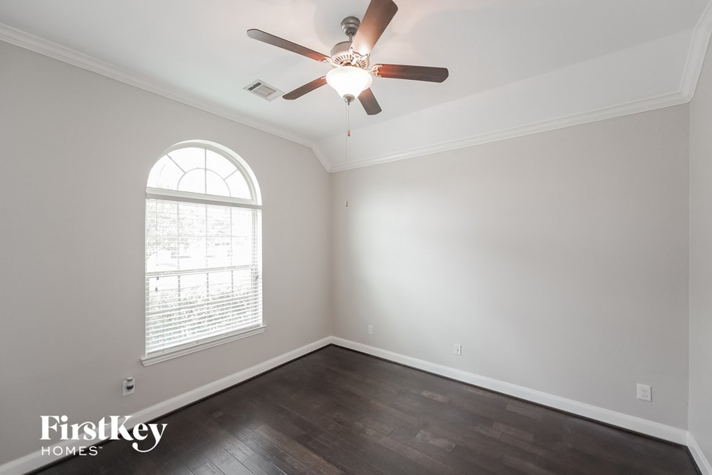 an empty room with a ceiling fan and a window