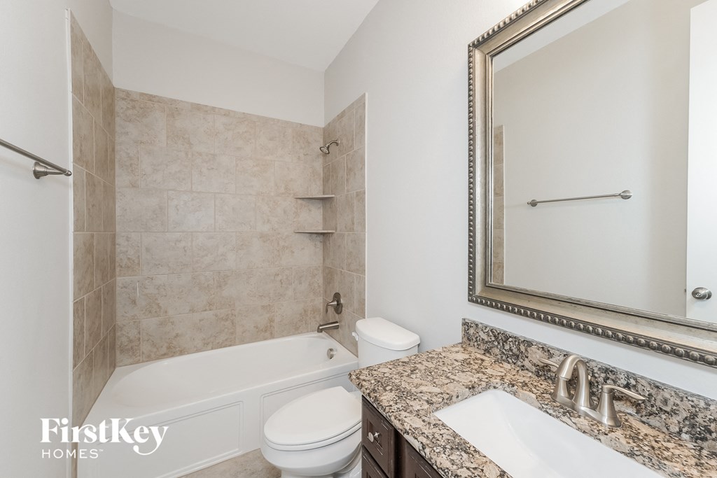 a bathroom with a tub and a sink and a mirror