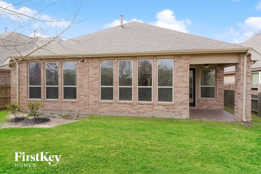 the front of a brick house with a lawn and a porch