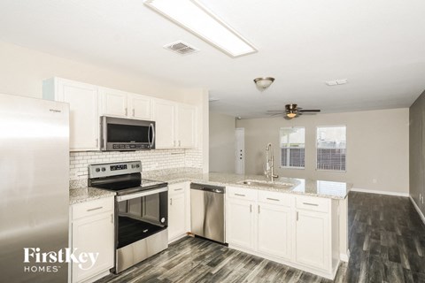 a kitchen with white cabinets and stainless steel appliances