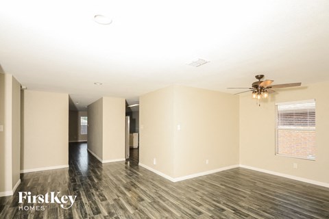 a living room with wood floors and a ceiling fan