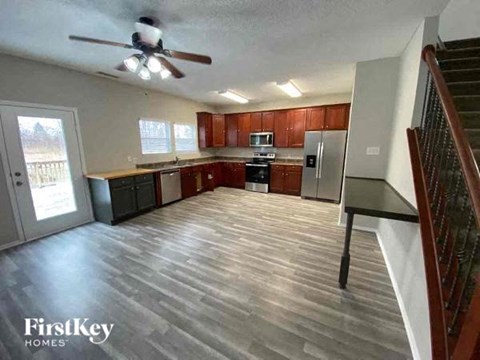 an empty kitchen with wood floors and a ceiling fan