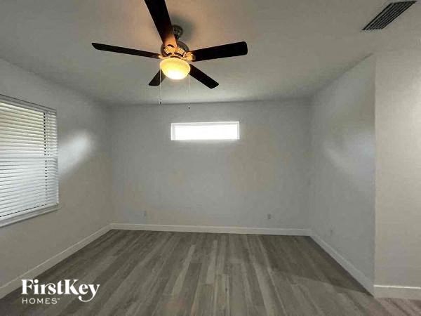 an empty room with a ceiling fan and a window