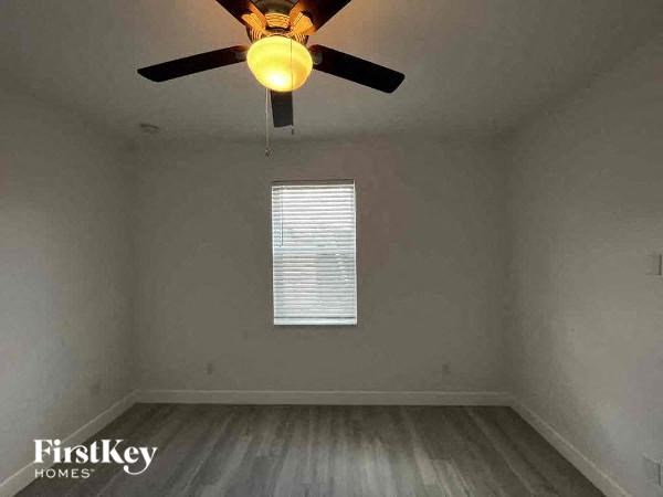 a empty room with a ceiling fan and a window
