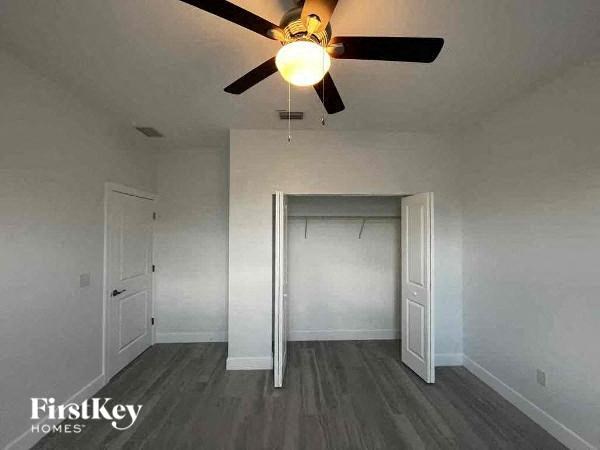 a empty room with a ceiling fan and a door to a closet