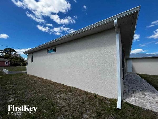 a white building with a roof and a driveway