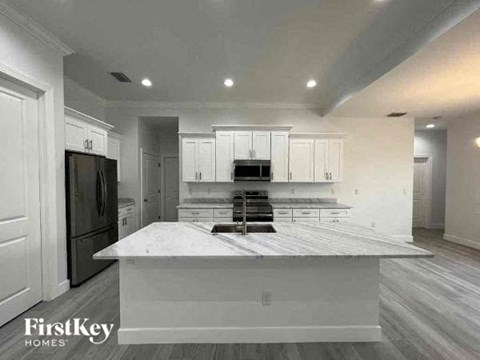 a white kitchen with a counter top and a refrigerator