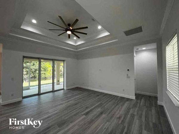 an empty living room with a ceiling fan