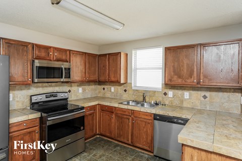 A kitchen with wooden cabinets and a stainless steel dishwasher.