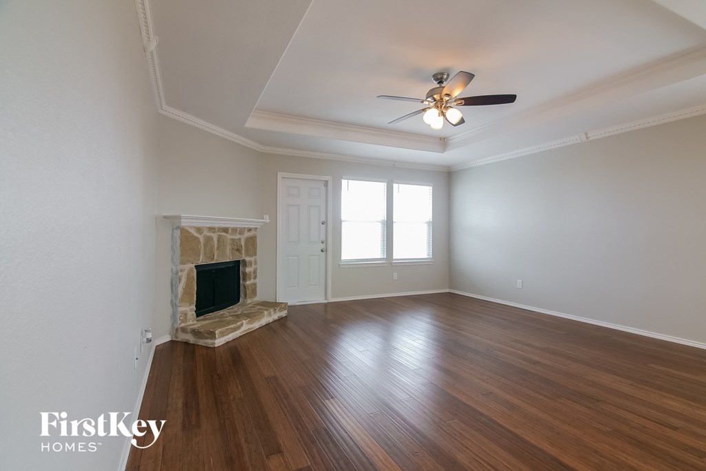 a living room with a fireplace and a ceiling fan
