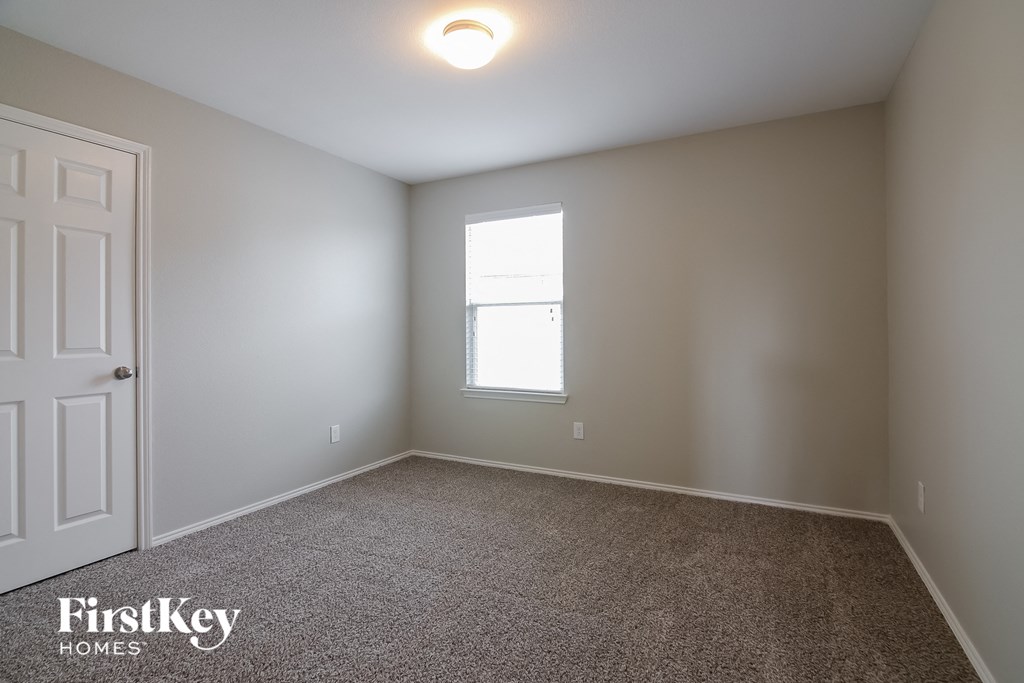 a empty room with a window and a white door