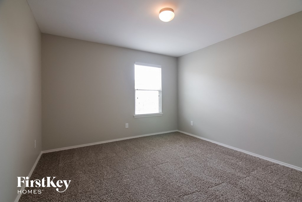 a empty room with carpet and a window