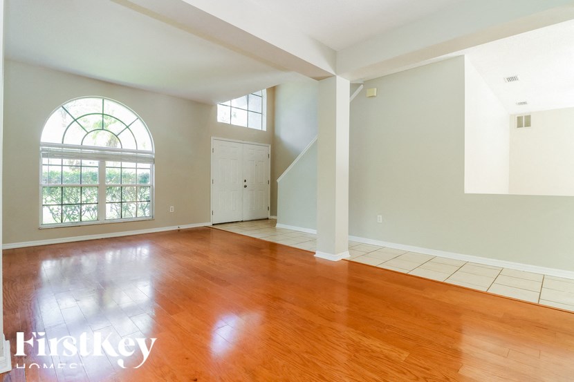 an empty living room with wood floors and a large window