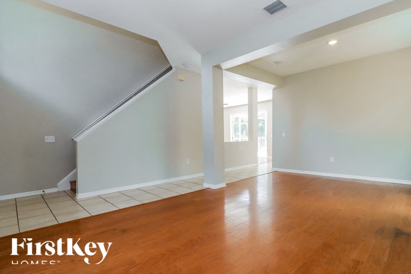 the living room and dining room with wood floors and white walls