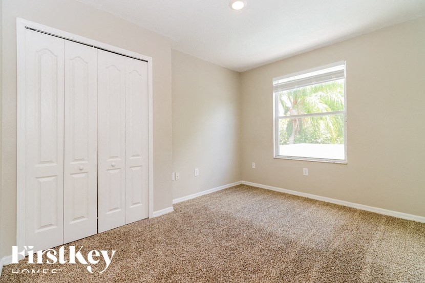 a bedroom with two white closets and a window