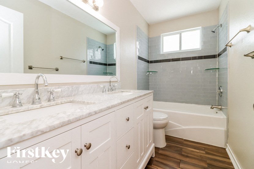 a bathroom with a white sink and a tub and a toilet and a mirror
