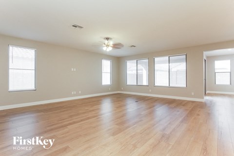 the spacious living room with hardwood flooring and windows