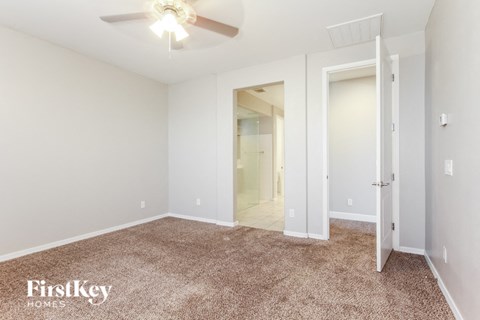 a bedroom with a carpeted floor and a ceiling fan