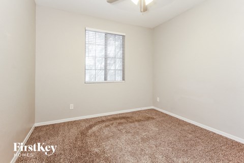 a spacious room with carpet and a window