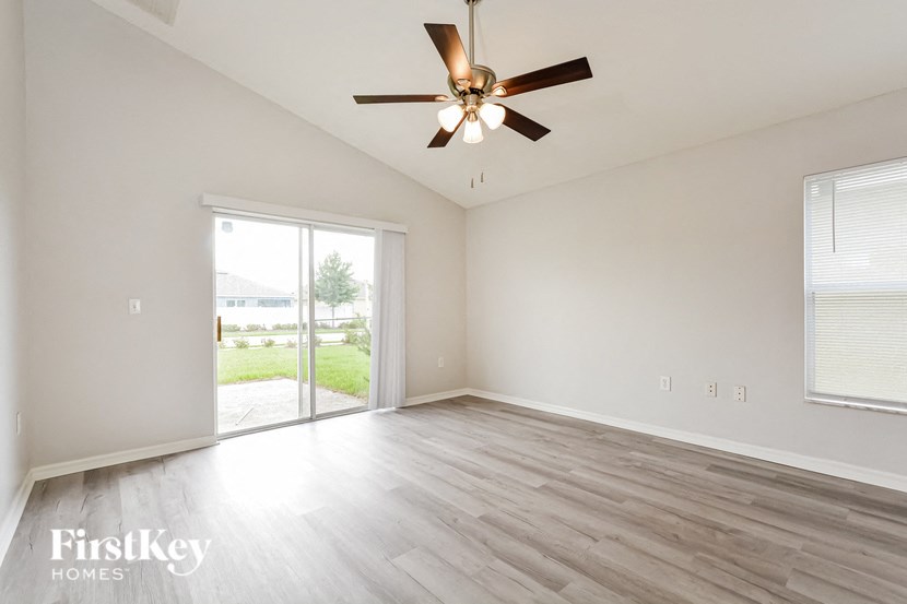 the living room of an empty house with a ceiling fan
