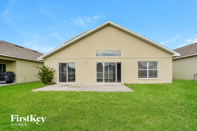 a beige house with a lawn and a driveway