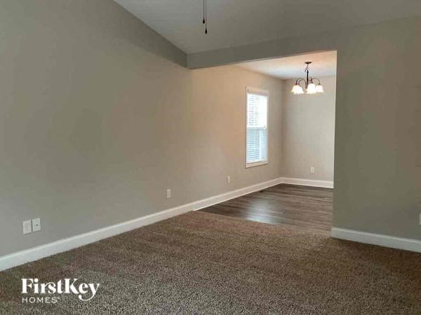A room with a carpeted floor and a window.